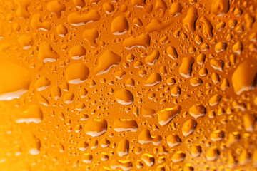 Close up drops of a Ice Cold Pint of Beer- condensation. Macro beer drink,Water drops background. The background on water drops on yellow-golden background.