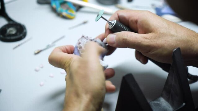 Dental technician works in his workshop and makes artificial teeth for dentistry. laboratory.