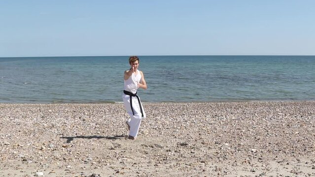 Teenage Black Belt Martial Artist Doing Karate on A Beach