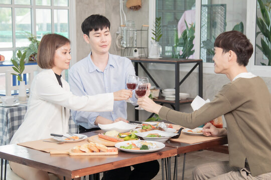 Young Asian colleague worker spent lunchtime together near office, group of friends dinner or luncheon talk in restaurant and take pictures with happy, young people in official dress lifestyle