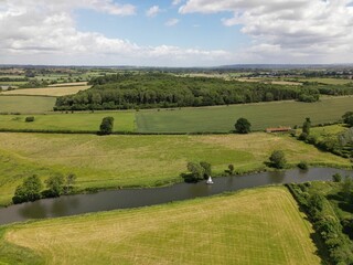 Aerial view of a canal in a green cultivated field on a sunny day