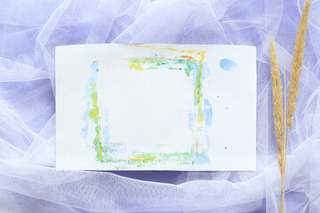 dry reed and paper sheet with free space on white tulle with violet background