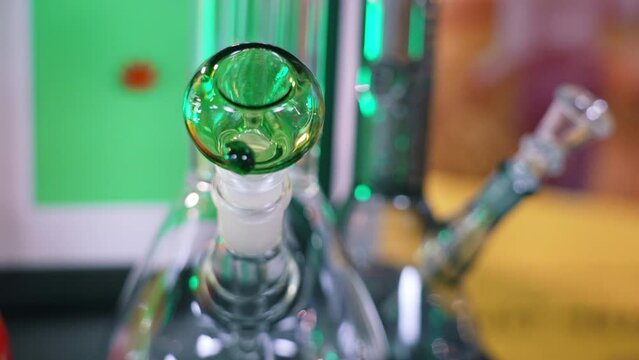 Closeup shot of the pipe of transparent glass smoking bong for marijuana and legal CBD CBG options. Smoking equipment. High quality 4k footage