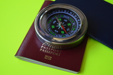 Red and blue passport with compass on green background, finding the right destination in the world for travel and business