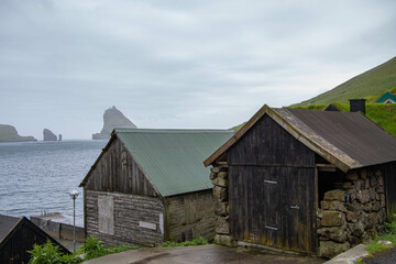 Fototapeta na wymiar Bootsschuppen in Bøur, im Hintergrund die Insel Tindholmur, Insel Vagar, Färöer Inseln