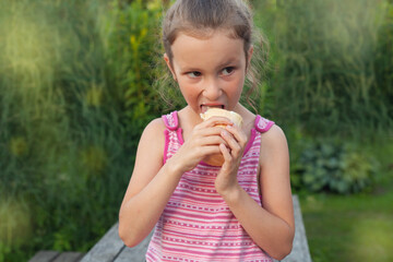 a six-year-old girl eats ice cream on the street