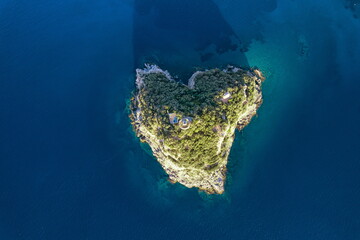 Aerial view from above of the beautiful heart-shaped natural island in the Mediterranean Sea along the coast of Liguria, Italy