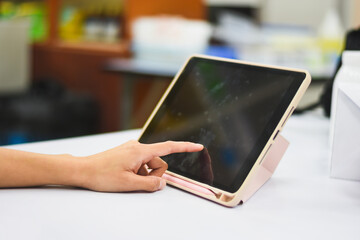 Close-up of Asian woman's hand pressing a tablet