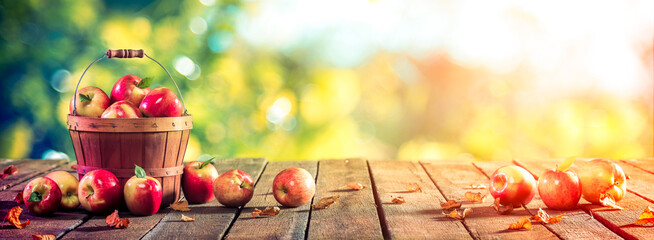 Apples In Wooden Basket On Table At Sunset - Autumn And Harvest Concept