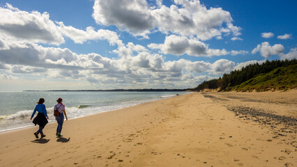 Two people walking down Kiltennel Beach, County Waterfor, Ireland.