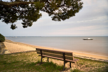 lonely bank at high tide in Arcachon Bay overlooking a ship at anchor
