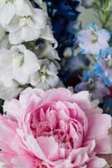 delicate bouquet of delphiniums and large pink peony
