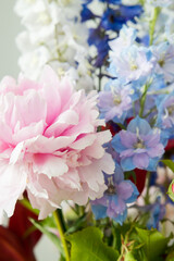 Fototapeta na wymiar delicate bouquet of delphiniums and large pink peony