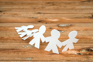 paper dolls symbol of friendship with wooden background