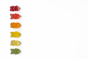 Obraz premium top view of gradient row of gummy bears on light background with negative space