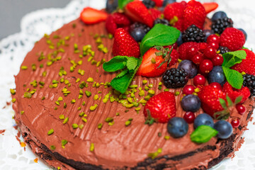 Delicious vegetarian chocolate cake with berries and pistachio  - 526317446