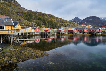 Fototapeta na wymiar Typical view of a fishing village with the houses reflecting on the water in Lofoten, in the Norwegian fjords.