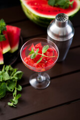 watermelon alcoholik or non- alcoholic cocktail with mint and shaker on dark background