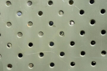 Lattice texture close up. Holes of grey metal plate with round regular holes texture background. Military Texture. Lattice construction on military vehicles green protective colors