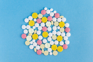 A bunch of colorful pills on a blue background