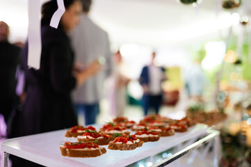 Bruschetta with feta cheese, roasted red sweet peppers and basil on a light wooden background. selective focus
