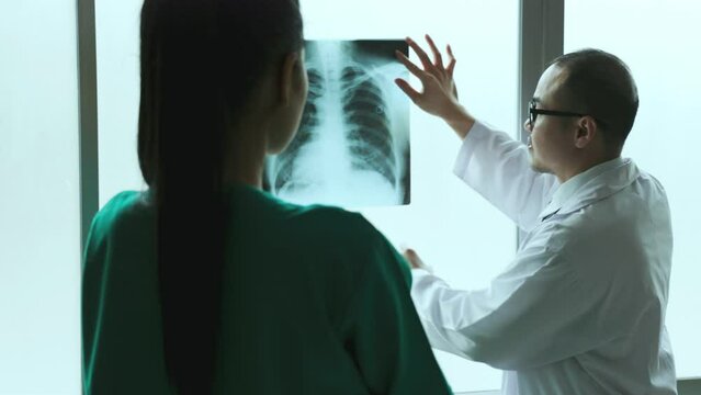 The doctor examine patient lungs  on Chest X-ray film