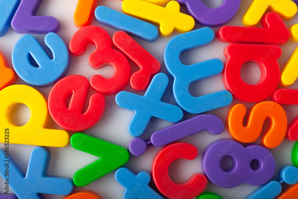 Fototapete plastic multi-colored alphabets letters on a magnet. lots of сolorful letters scattered on a white b