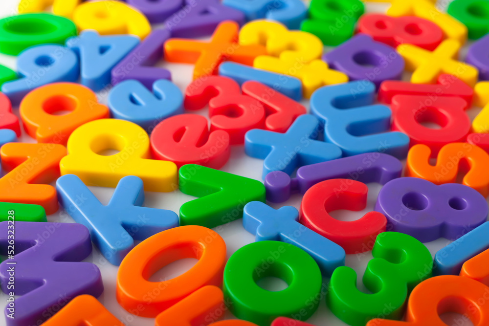 Fototapete plastic multi-colored alphabets letters on a magnet. lots of сolorful letters scattered on a white b