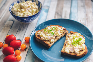 Fresh spread on the toast with tomatoes and blue dishes