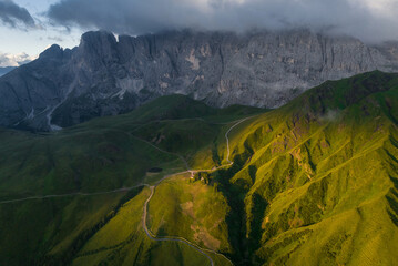 Sunrise in the Dolomites mountains with fog and mist rolling around the peaks. Hiking path leading...