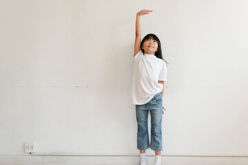 Kid is measuring the growth on the background of wall. Girl power concept.