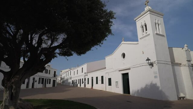 Tree and whitewashed church in Fornells, Menorca, Balearic Islands