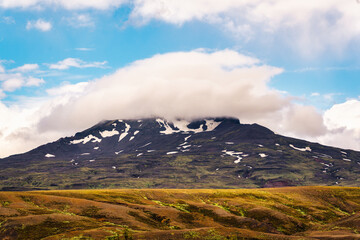 Fototapeta premium Natural pileus cloud covered on volcanic mountainin Icelandic Highlands on daylight at Thorsmork, Iceland