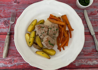 Pork medallions with honey carrots, oven potatoes and cream sauce.