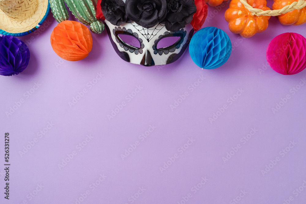 Wall mural Día de los Muertos day of the dead holiday concept. Sugar skull mask and Mexican party decorations on purple background. Top view, flat lay