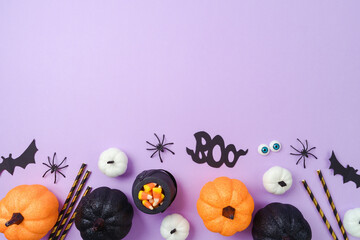 Halloween banner template design. Glitter pumpkin, candy and decorations on purple background. Top view, flat lay