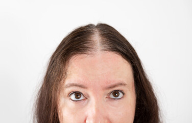 Woman checking hair loss and without volume over isolated white background looking up sad, upset,...