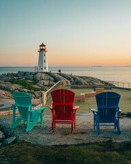 Peggys Cove Lighthouse with Adirondack chairs at sunset, Peggys Cove, Nova Scotia, Canada