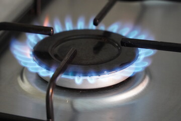Closeup shot of blue fire from domestic kitchen stove top, gas cooker with burning flames of propane gas