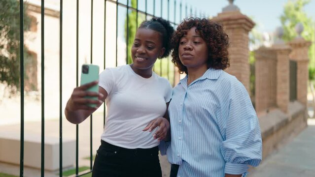 African american women mother and daughter make selfie by smartphone at street