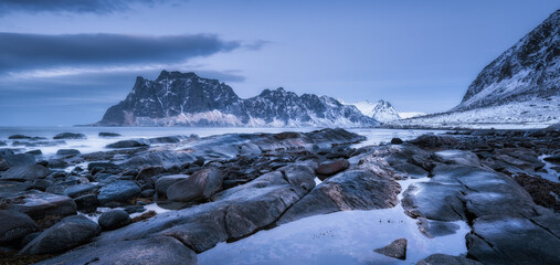 Rocky beach in winter at night. Sea coast with stones