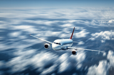 Airplane is flying above the low clouds in summer