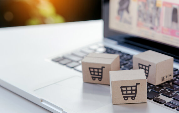 Shopping online. Cardboard box with a shopping cart logo on laptop keyboard. Shopping service on The online web. offers home delivery.