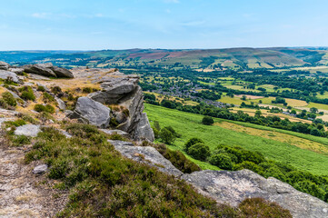 Fototapeta na wymiar A view down towards the Hope Valley from the rocky top of Bamford Edge, UK in summertime