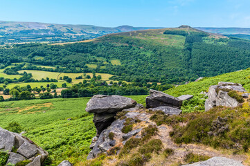 A view down towards the Hope Valley past the rocky outcrops of Bamford Edge, UK in summertime