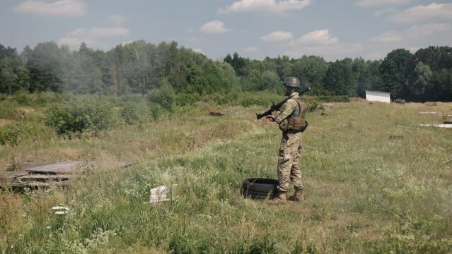 An armed soldier wearing a helmet, military uniform, and body armor fires a Precision Shoulder-Fired Rocket Launcher RPG-7 PSRL-1 at an enemy with a rocket that hit its mark precisely