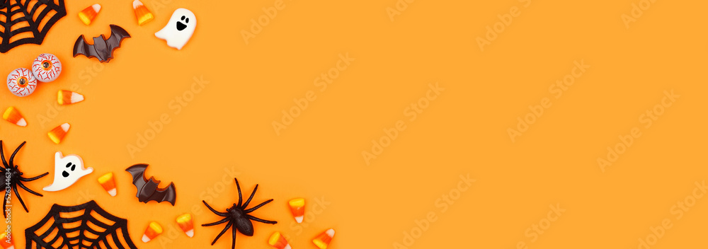 Poster halloween corner border of scattered candy and decor. above view over an orange banner background wi