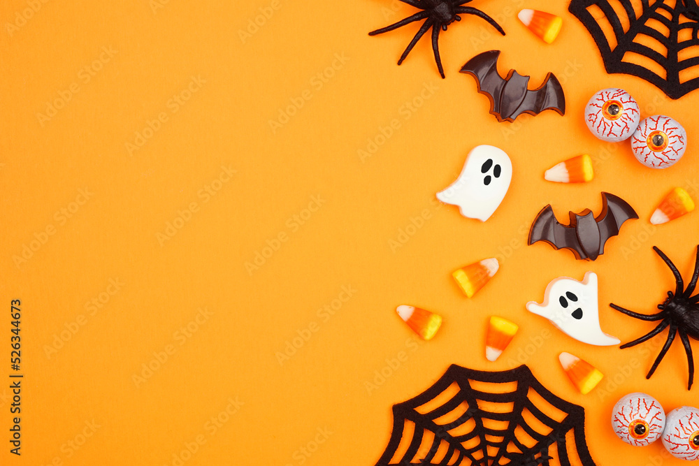 Poster halloween side border of scattered candy and decor. overhead view over an orange background with cop