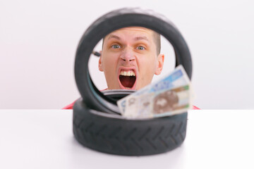 Money laying down on a two small scooter tire with a screaming man on the background. Wheel....