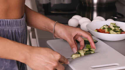 Human hands cooking vegetables salad in kitchen.